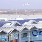 Rooftops of an airport with a plane in the background