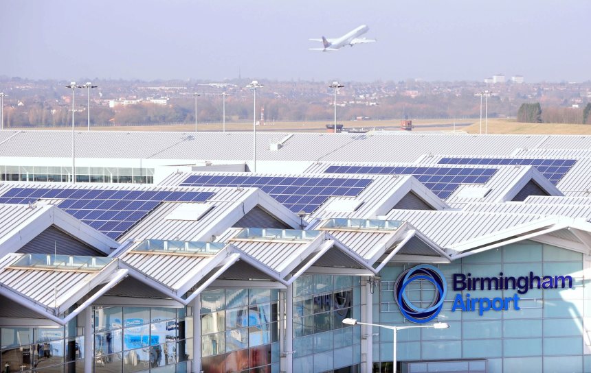 Rooftops of an airport with a plane in the background