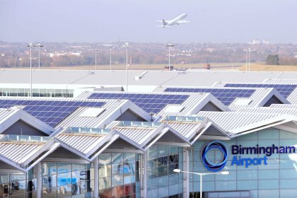 Rooftops of an airport with a plane in the background