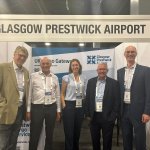 5 people stand below a sign saying Glasgow Prestwick Airport