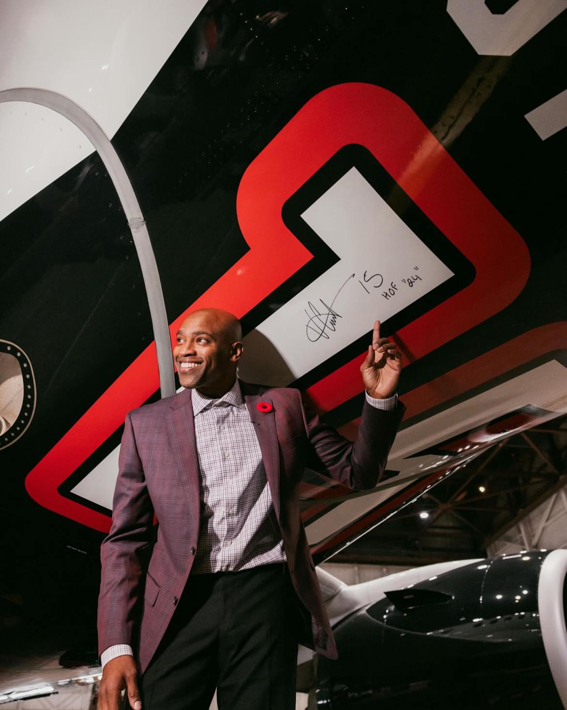 Image of smiling Vince Carter with the Air Canada aircraft that he has signed