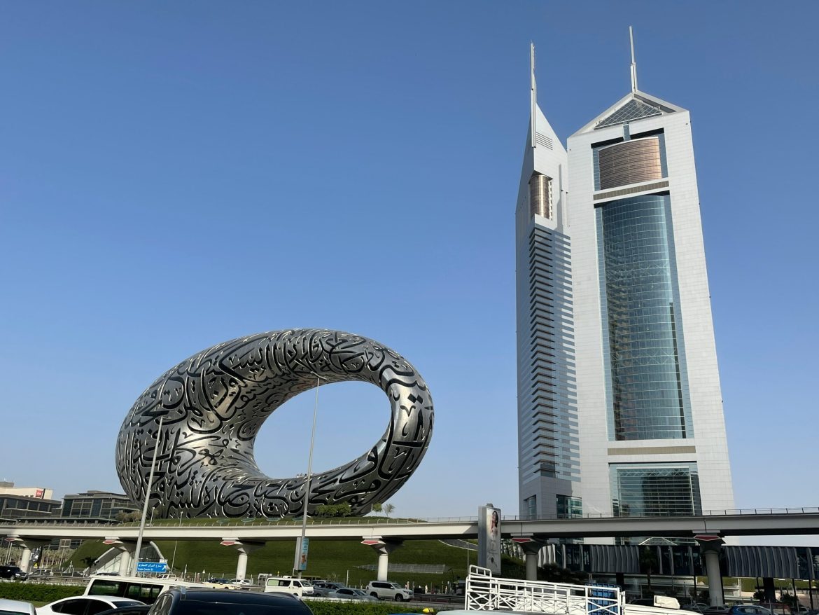 Two silver buildings against a blue sky