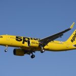 Spirit Airlines Airbus A320 ascends into the clear blue sky.