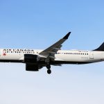 Air Canada A220 flying in a blue sky