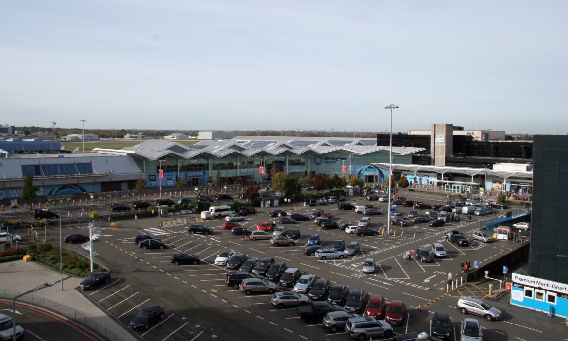 An airport terminal and car park from above