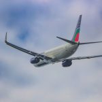 a large jetliner flying through a cloudy blue sky