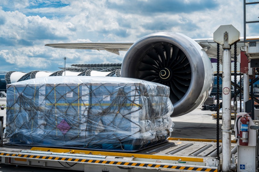 Air cargo logistic containers are loading to an airplane. Air transport shipment prepare for loading to modern freighter jet aircraft at the airport.