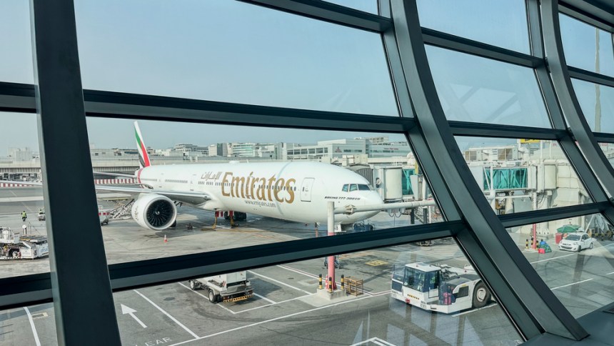 DUBAI, UAE. 16 SEPTEMBER 2023. In departure, view through glass: Boeing 777, passengers boarding, a prelude to the imminent journey