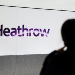 A person's silhouette in front of a Heathrow sign