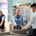 A lady in uniform checks baggage at an airport