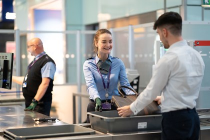 A lady in uniform checks baggage at an airport