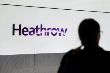 A person's silhouette in front of a Heathrow sign