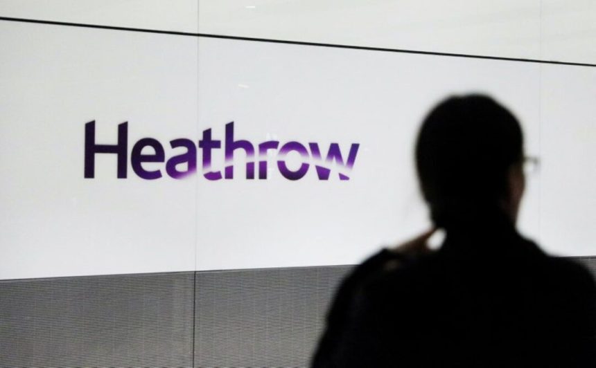 A person's silhouette in front of a Heathrow sign