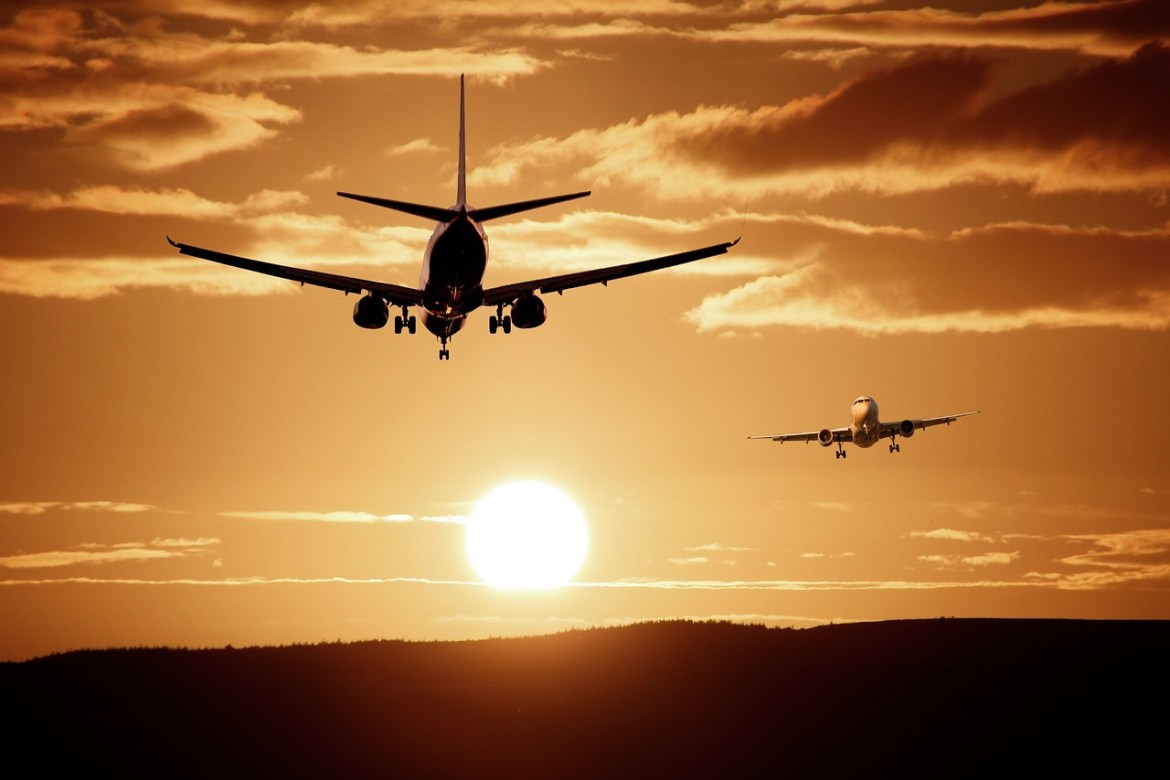 The image of two flying planes against the sunset. 