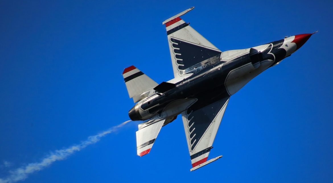 A jet flying against a blue sky. 