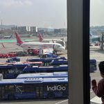 A boy looks at aircraft in an airport