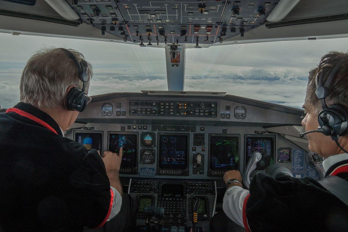 The image of two pilots in a plane cockpit.